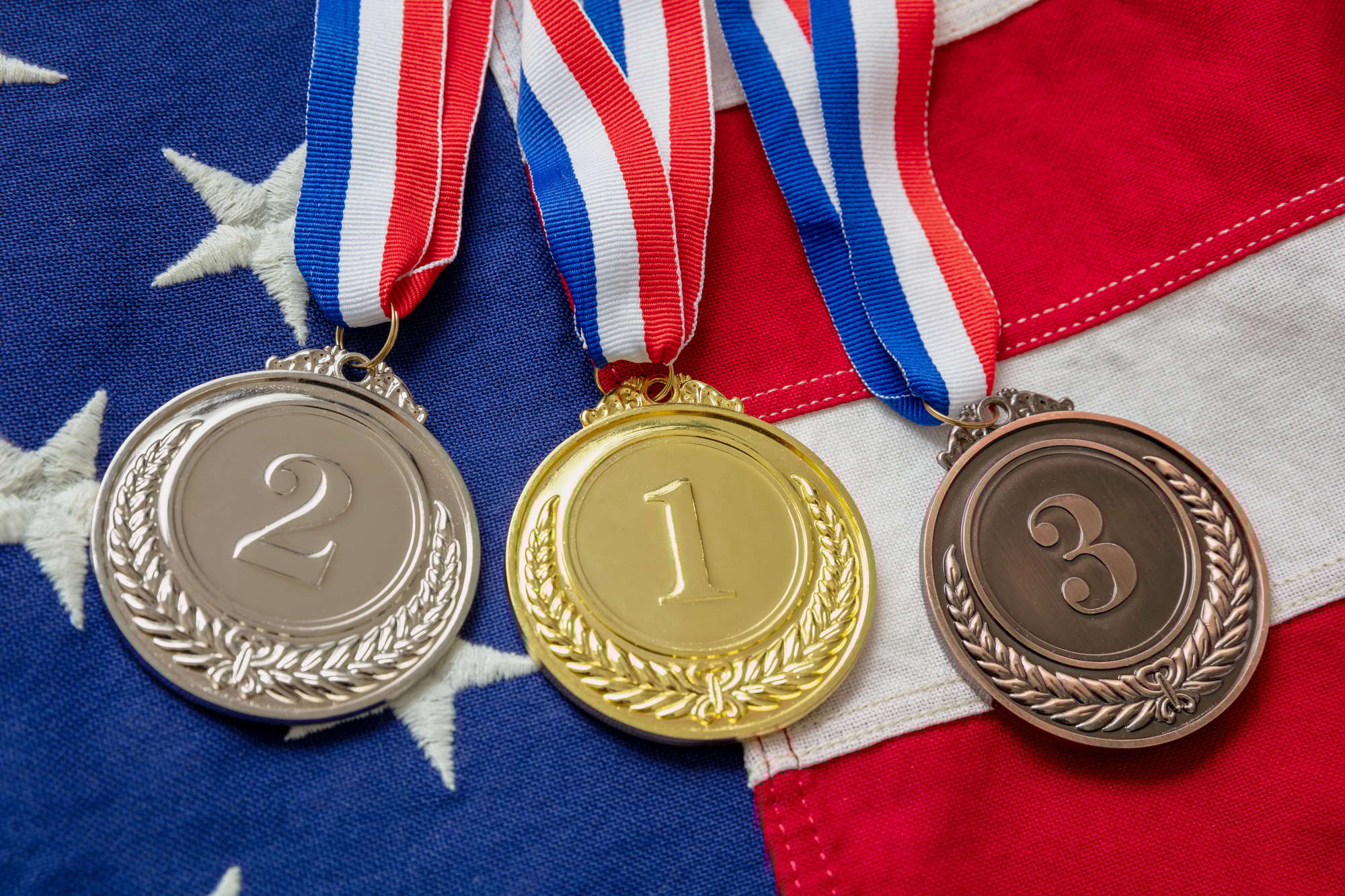 Gold, silver and bronze medals set on USA flag background. Sports athletes winners prize Gold, silver and bronze medals set on USA flag background. Sports athletes winners prize