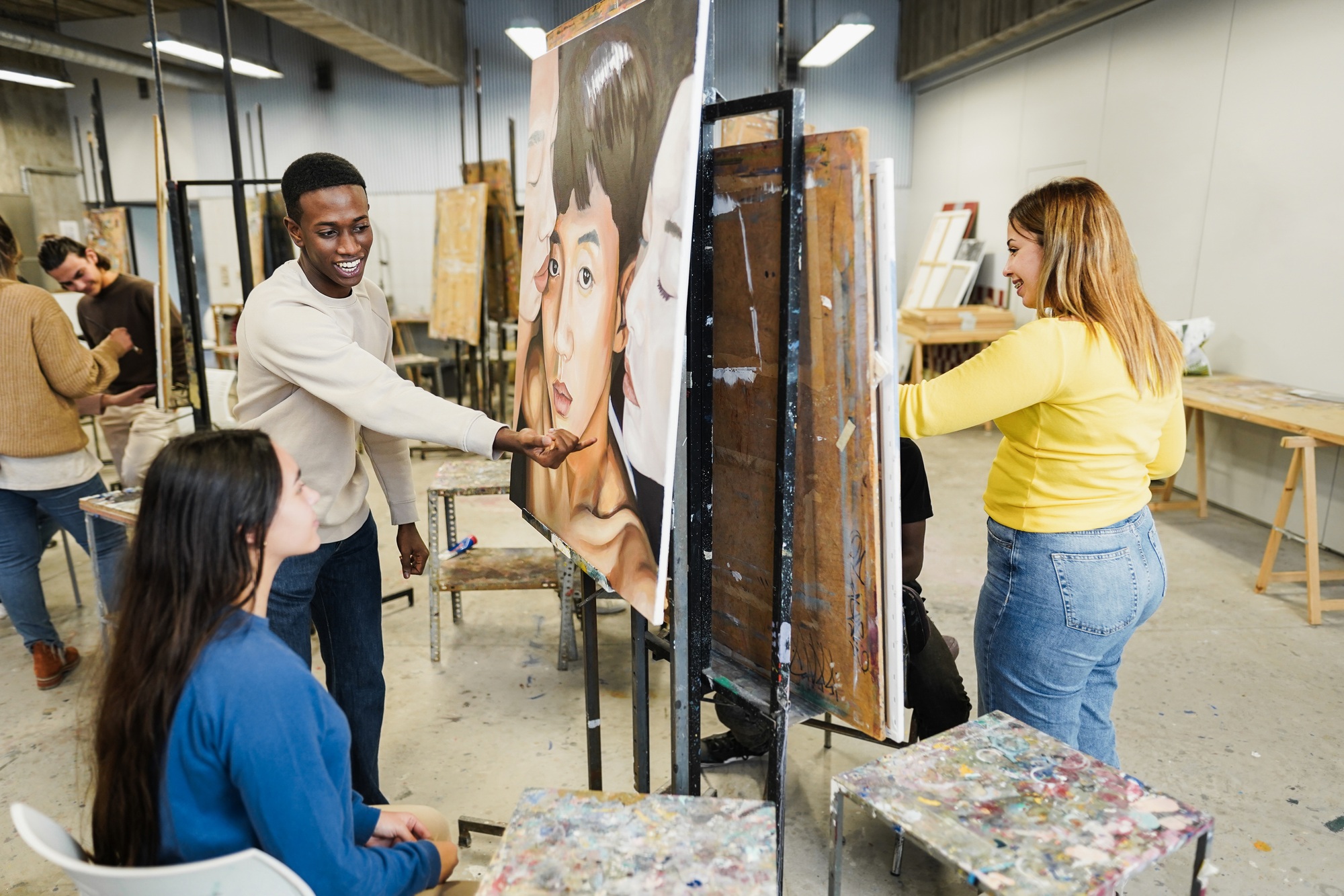 Multiracial students painting inside art room class at university – Focus on african guy face Multiracial students painting inside art room class at university - Focus on african guy face