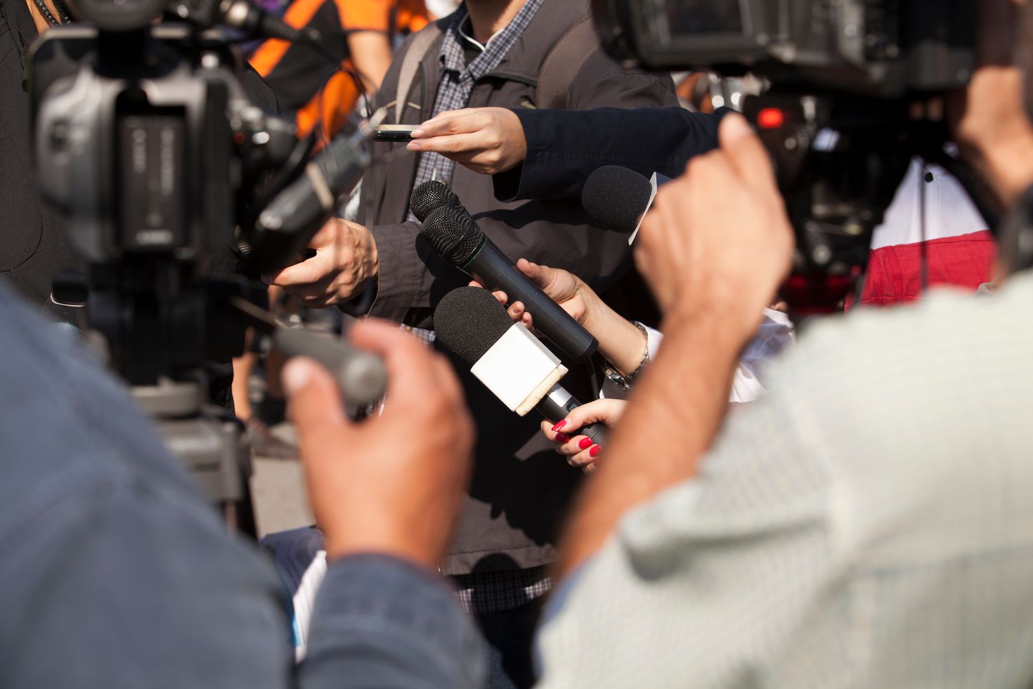 close-up-of-photographers-and-journalist-at-press-conference-918723520-5c70b40146e0fb00017189ee